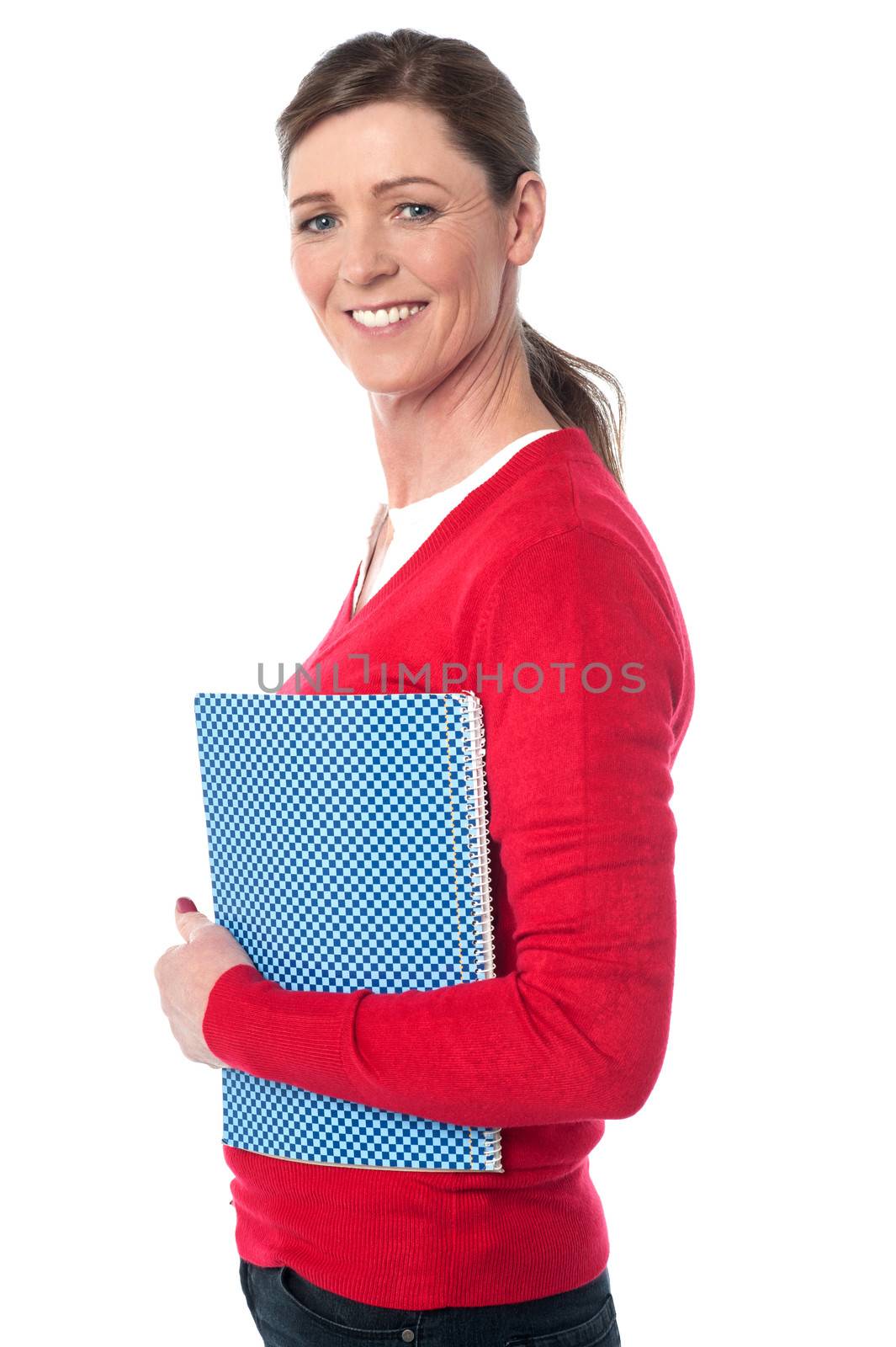 Pretty smiling woman holding notebook by stockyimages