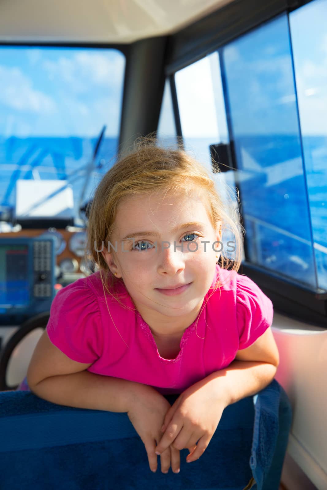 Blond kid girl at boat indoor sailing smiling happy by lunamarina