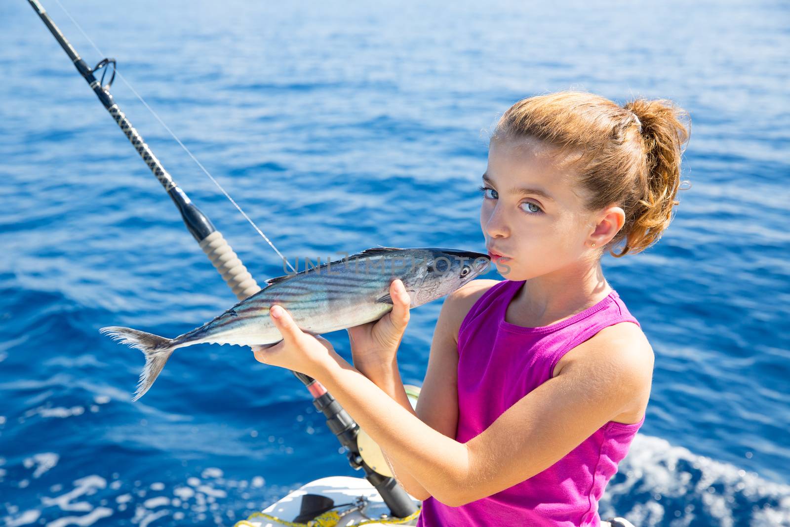 kid girl fishing tuna bonito sarda kissing fish for release due little size