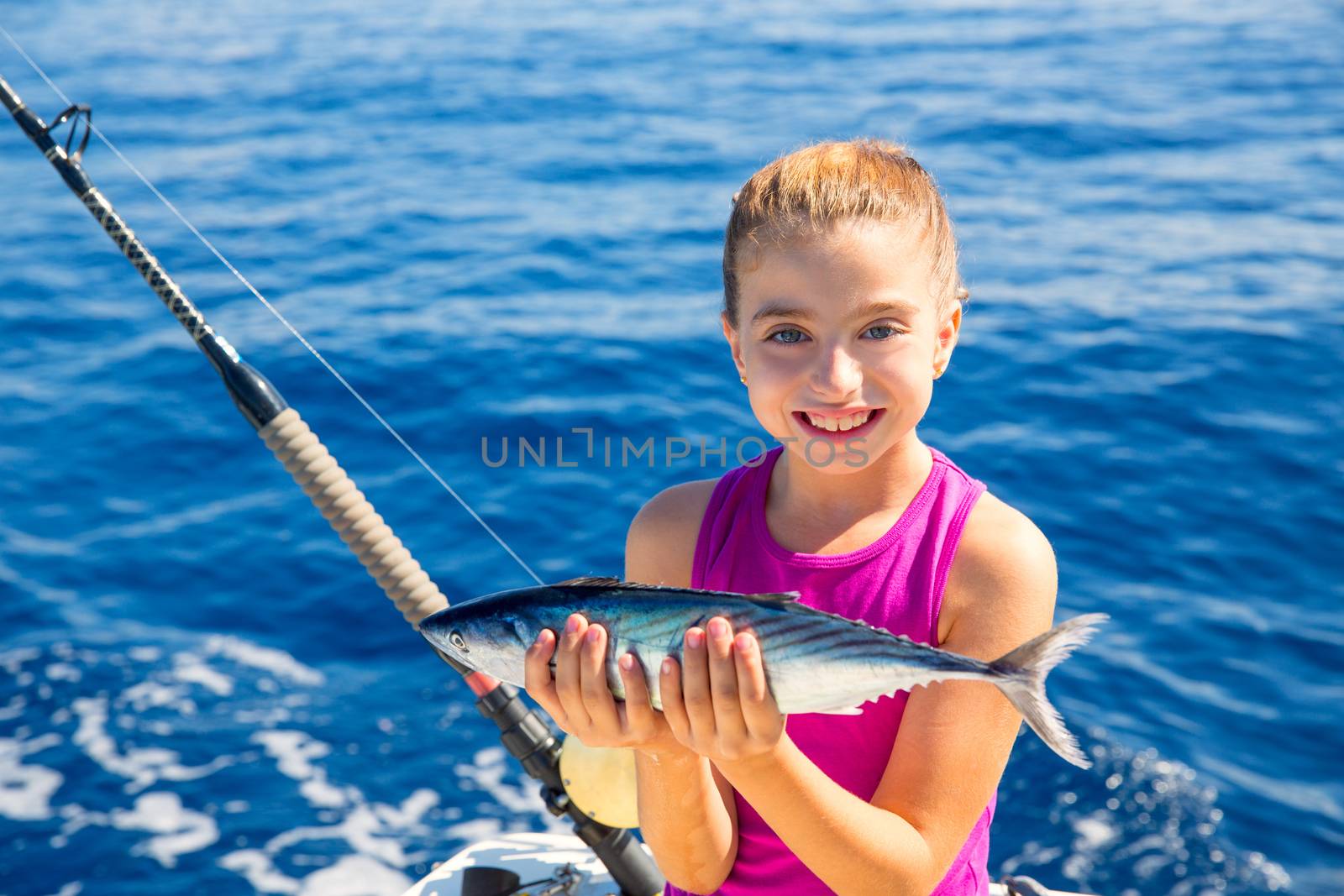 kid girl fishing tuna bonito sarda fish happy with trolling catch on boat deck