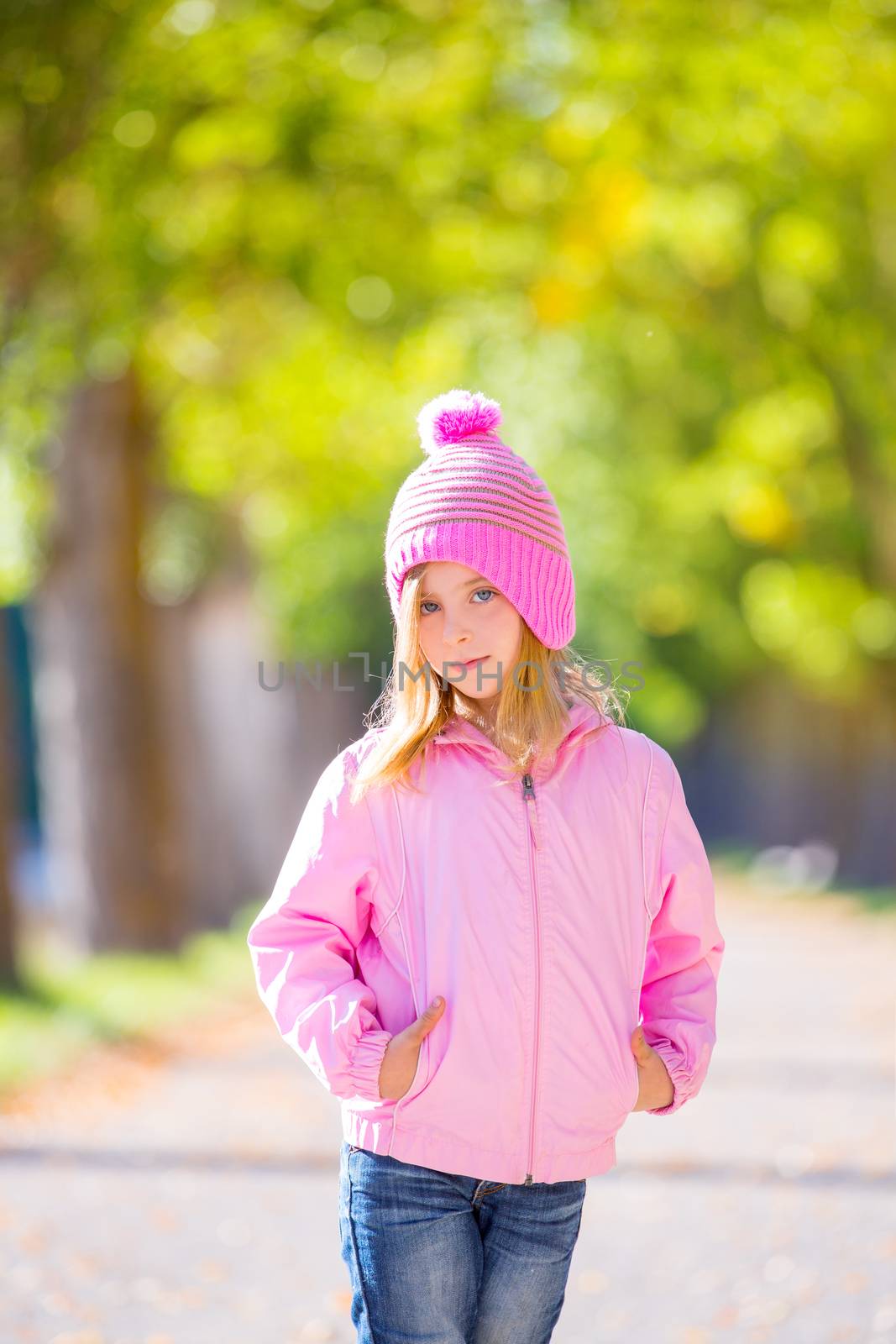 autumn winter kid girl blond with jeans and pink snow cap by lunamarina