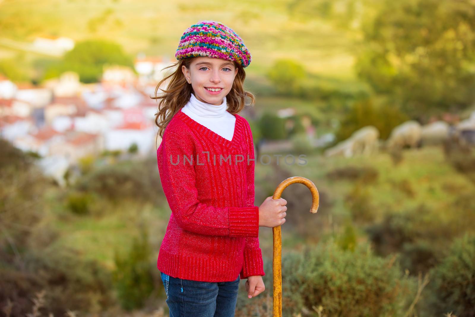 Kid girl shepherdess smiling with wooden baston in Spain village