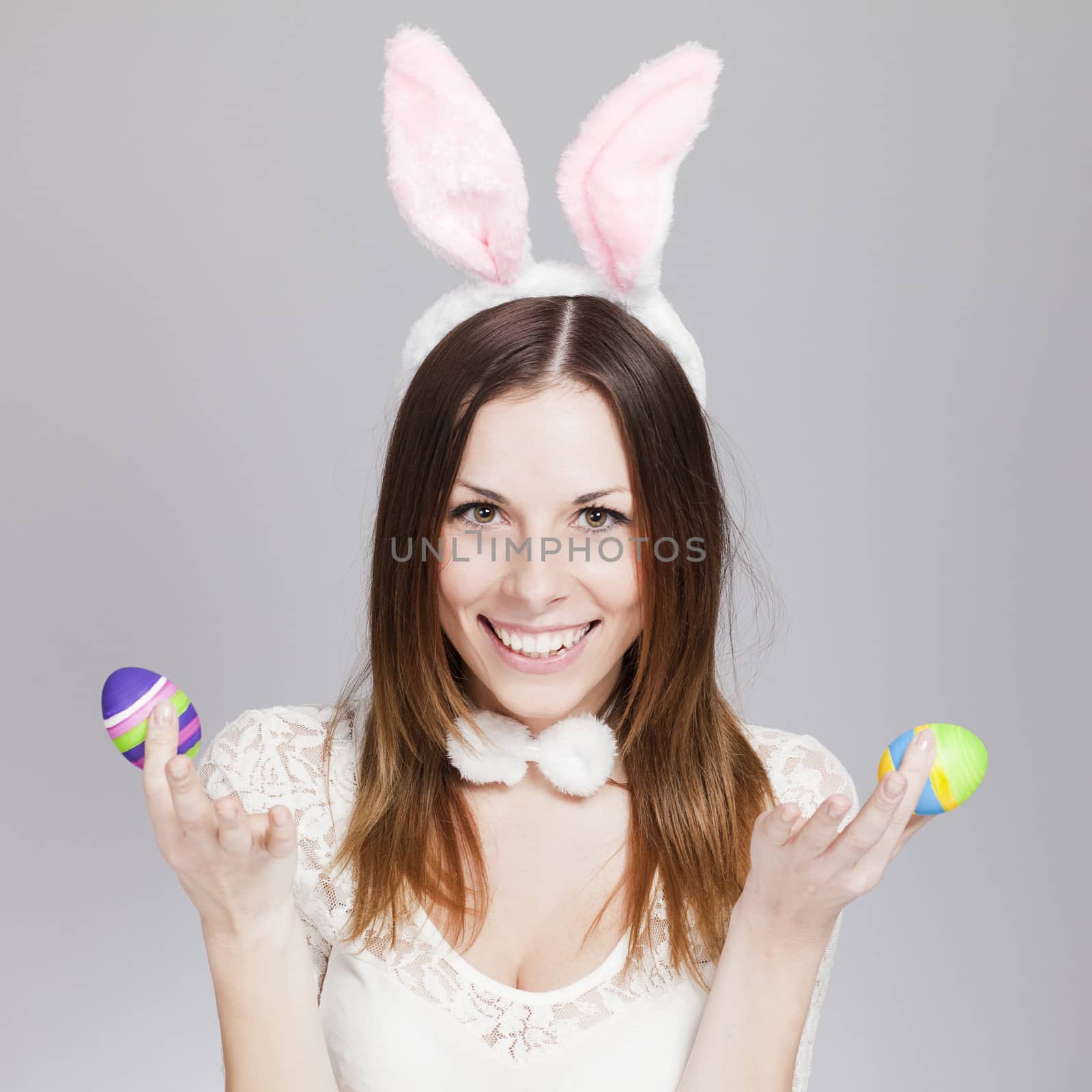 Brunette smiling and holding painted easter eggs