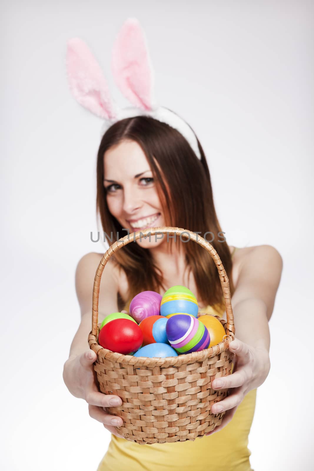 Brunette smiling and holding easter egg basket