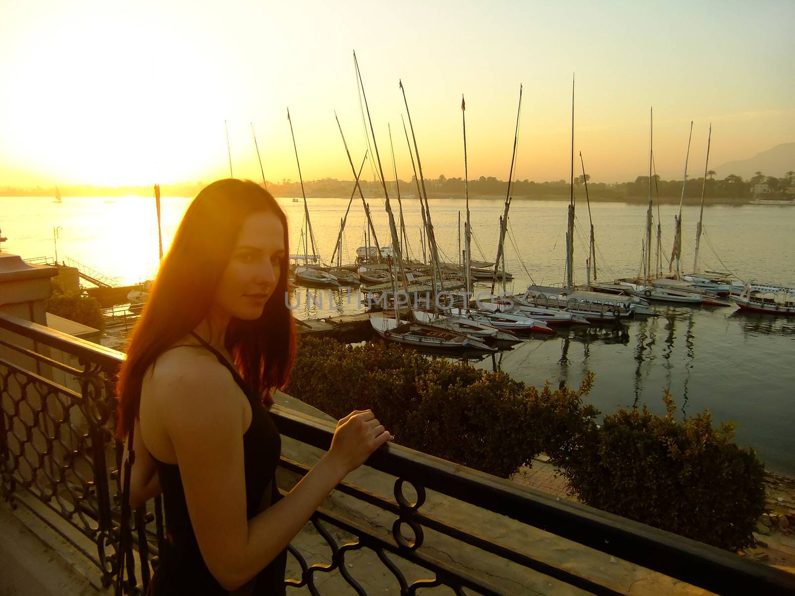 Young woman admiring sunset over the Nile river, Luxor, Egypt