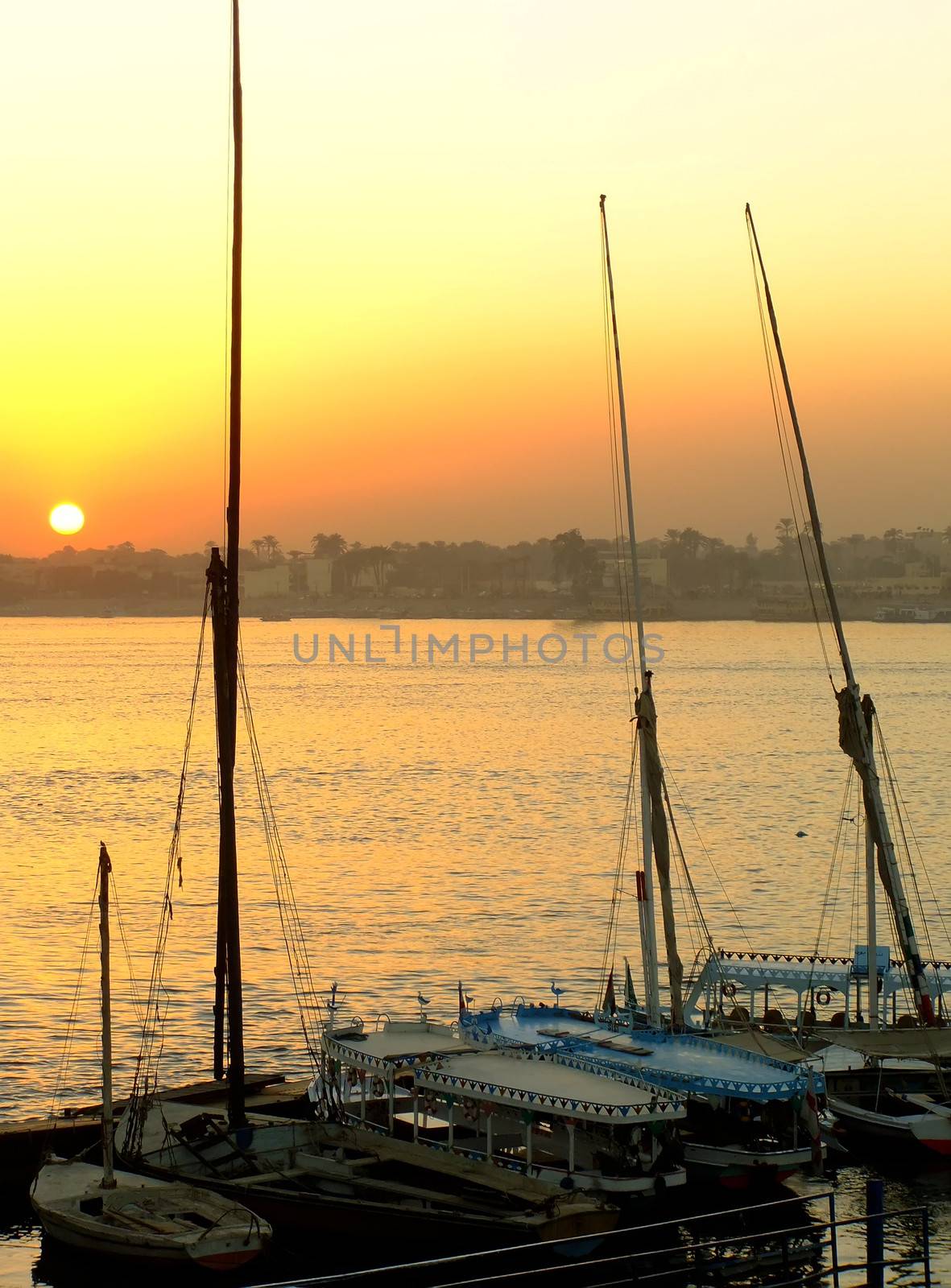 Felucca boats at the harbor at sunset, Luxor by donya_nedomam