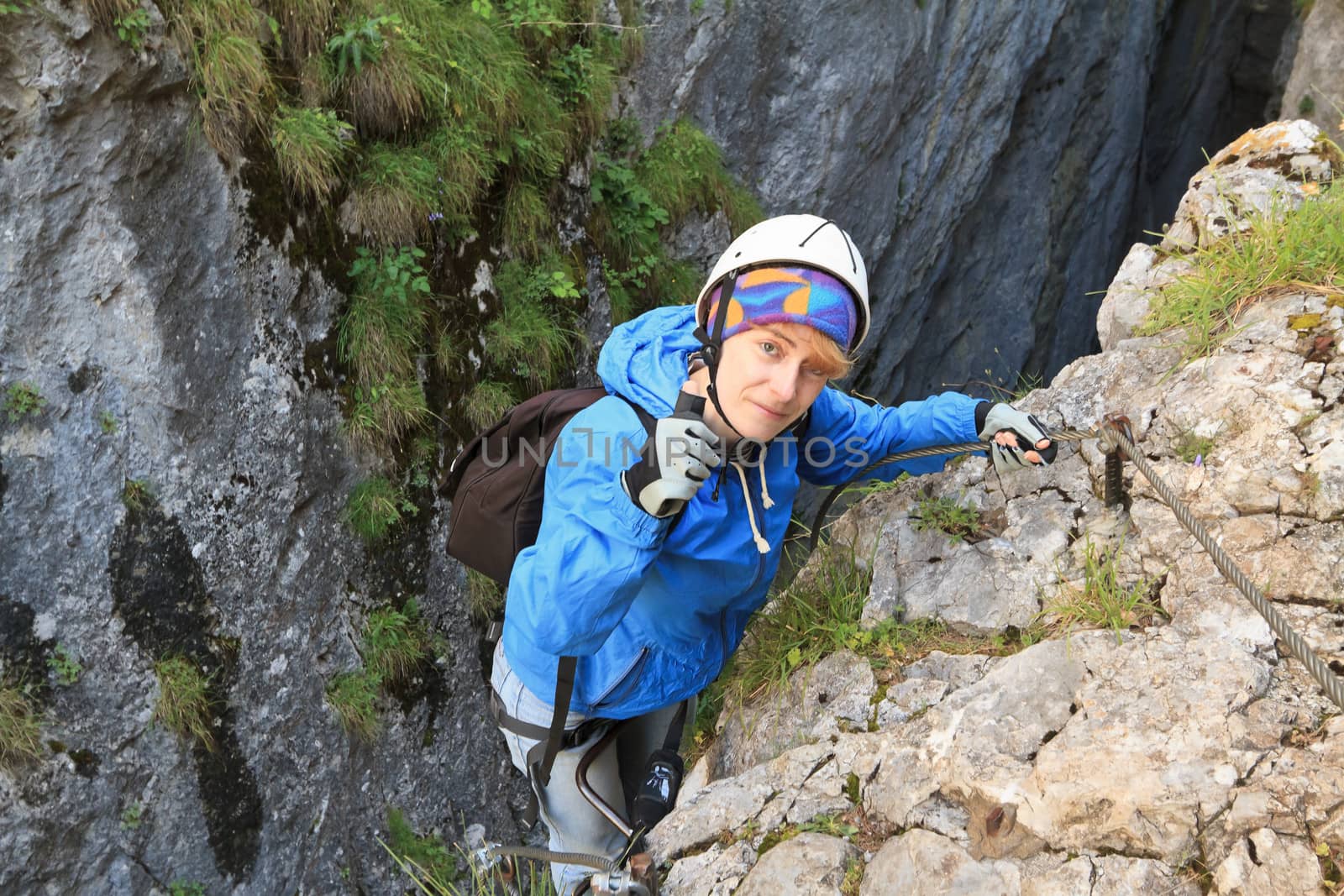 female climber with white helmet on via ferrata, italian Dolomites