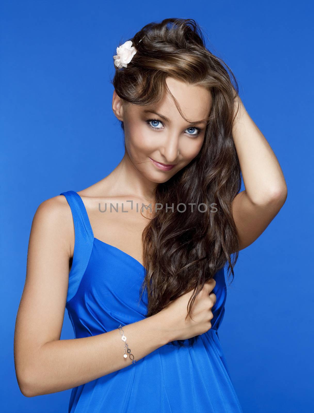 beautiful woman with brown hair and blue eyes isolated on blue