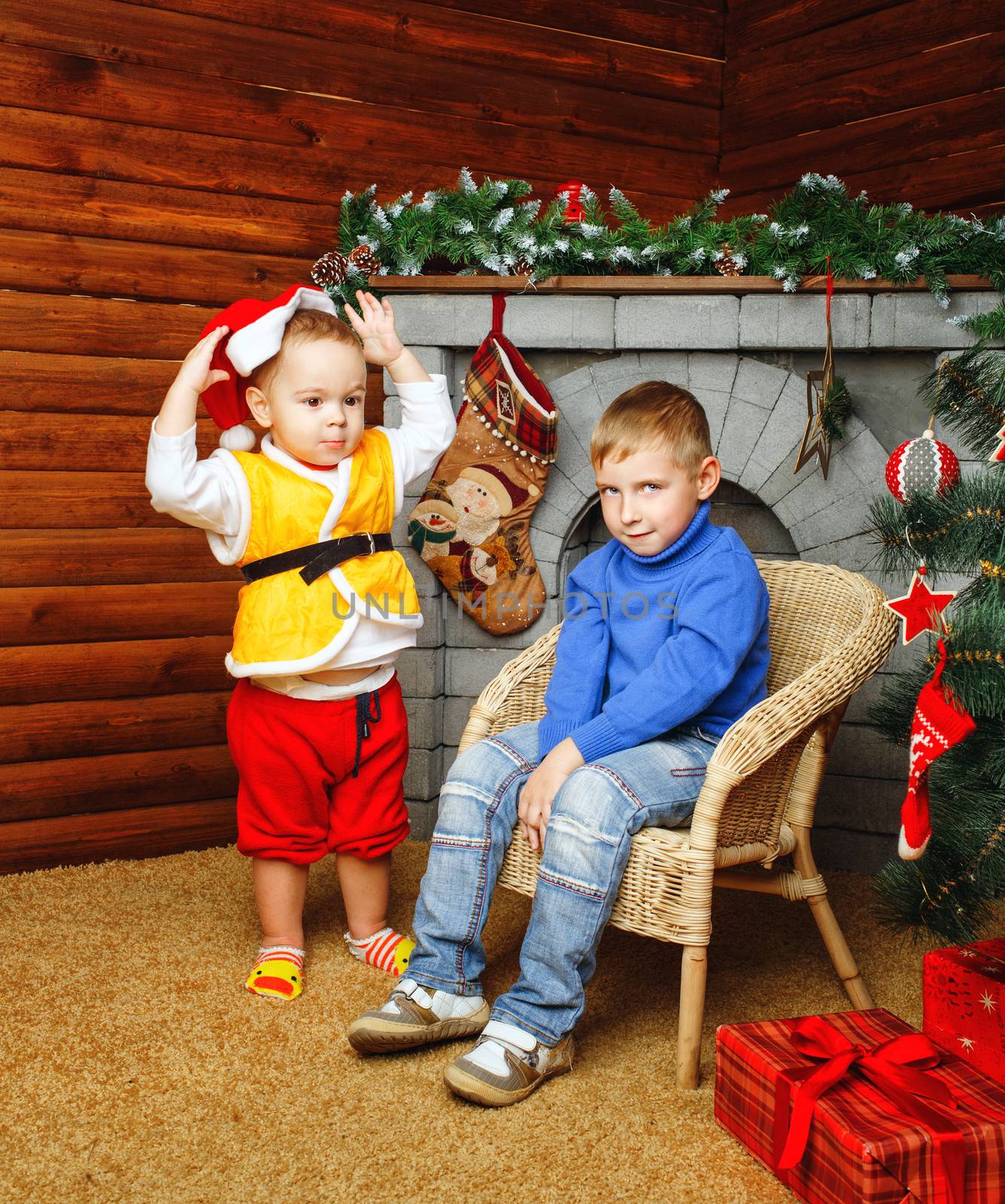 Two brothers near decorated Christmas tree pending holiday