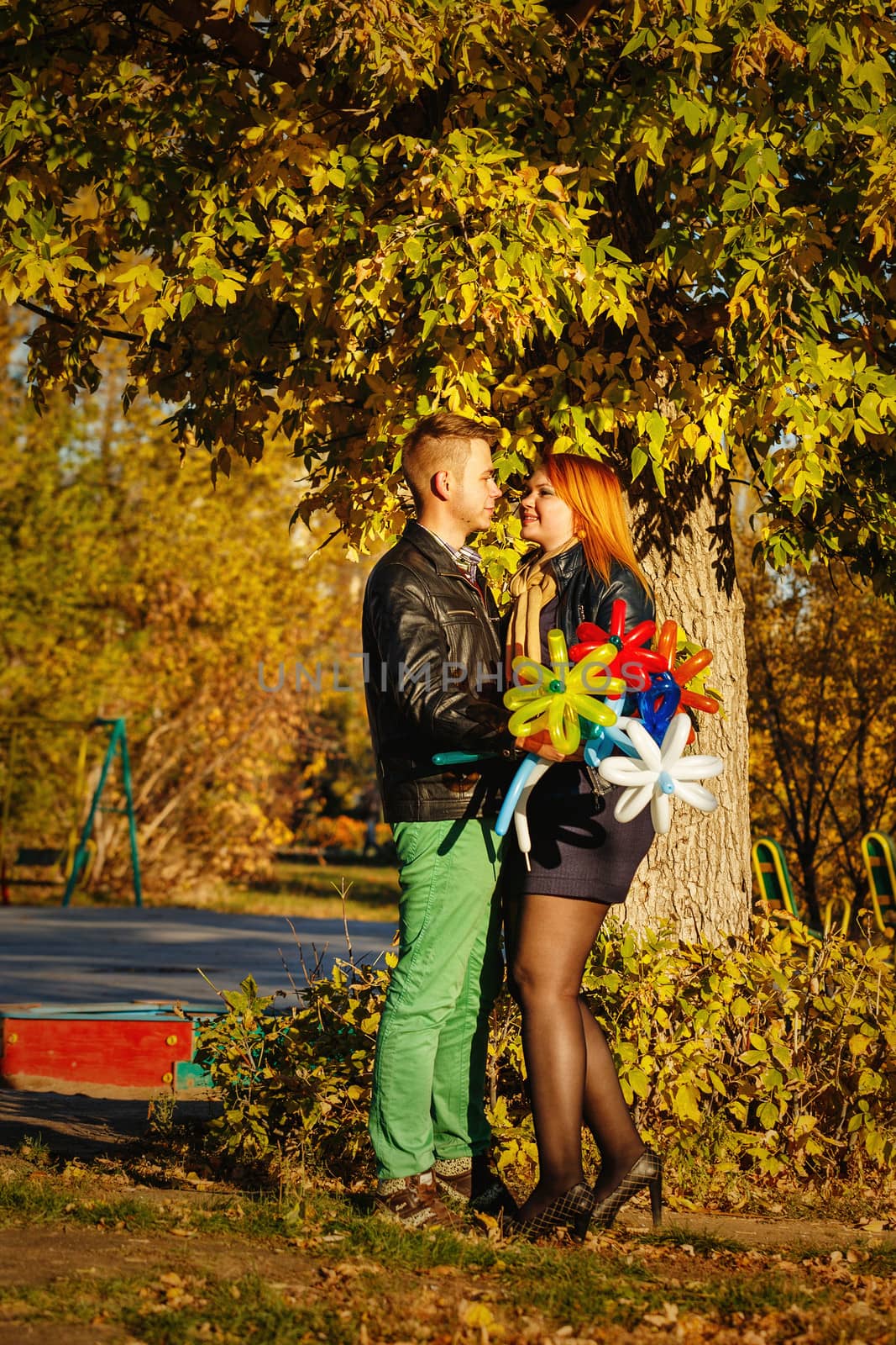 Young couple tenderly and lovingly looking at each other in autumn park