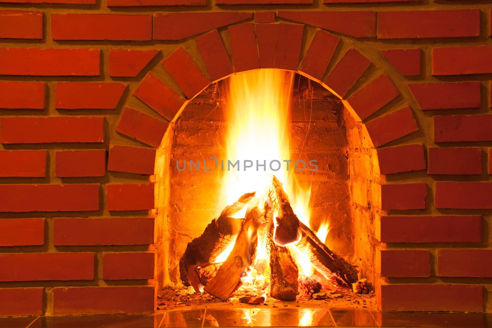 Burning fire in the brick fireplace, close up