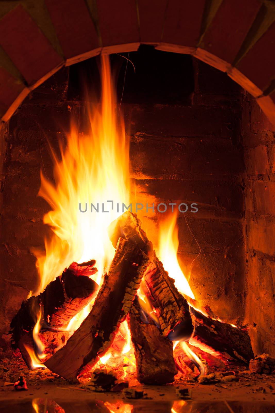 Burning fire in the brick fireplace, close up