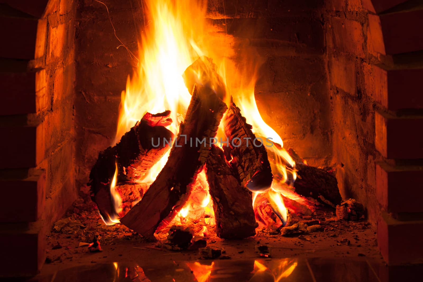 Burning fire in the brick fireplace, close up