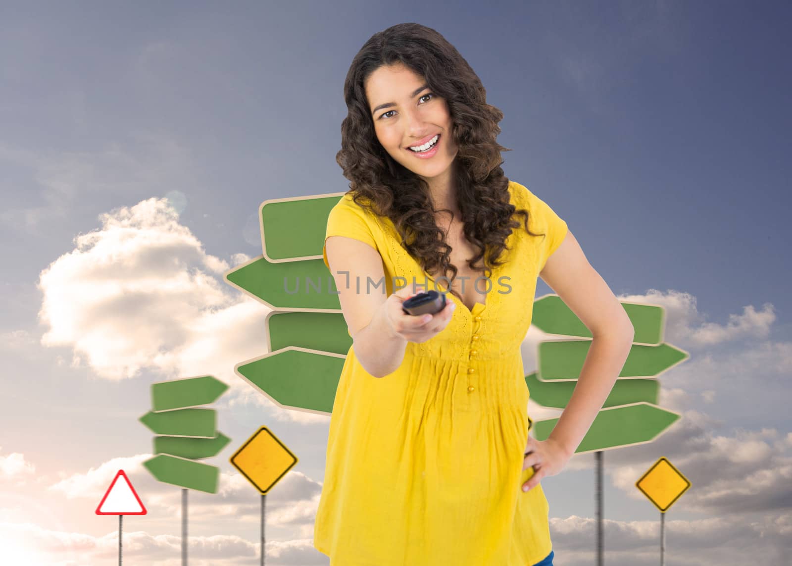 Composite image of smiling curly haired pretty woman changing channel with remote by Wavebreakmedia