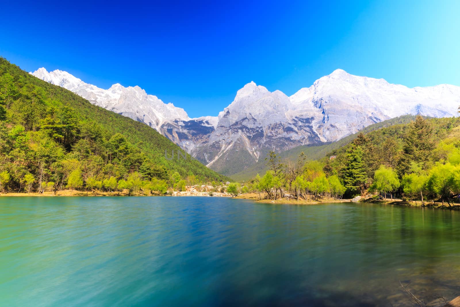 A view of a river and Jade Dragon Snow Mountain in Lijiang (Southwest China).
