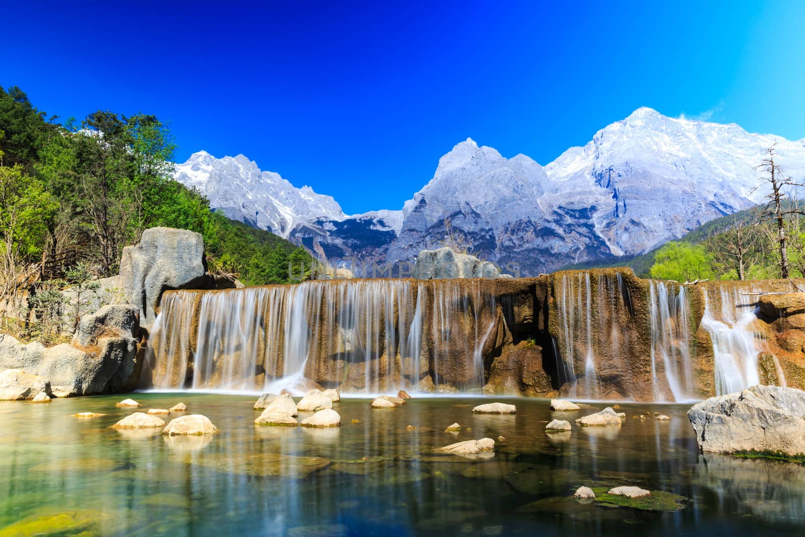 A view of a river and Jade Dragon Snow Mountain in Lijiang (Southwest China).