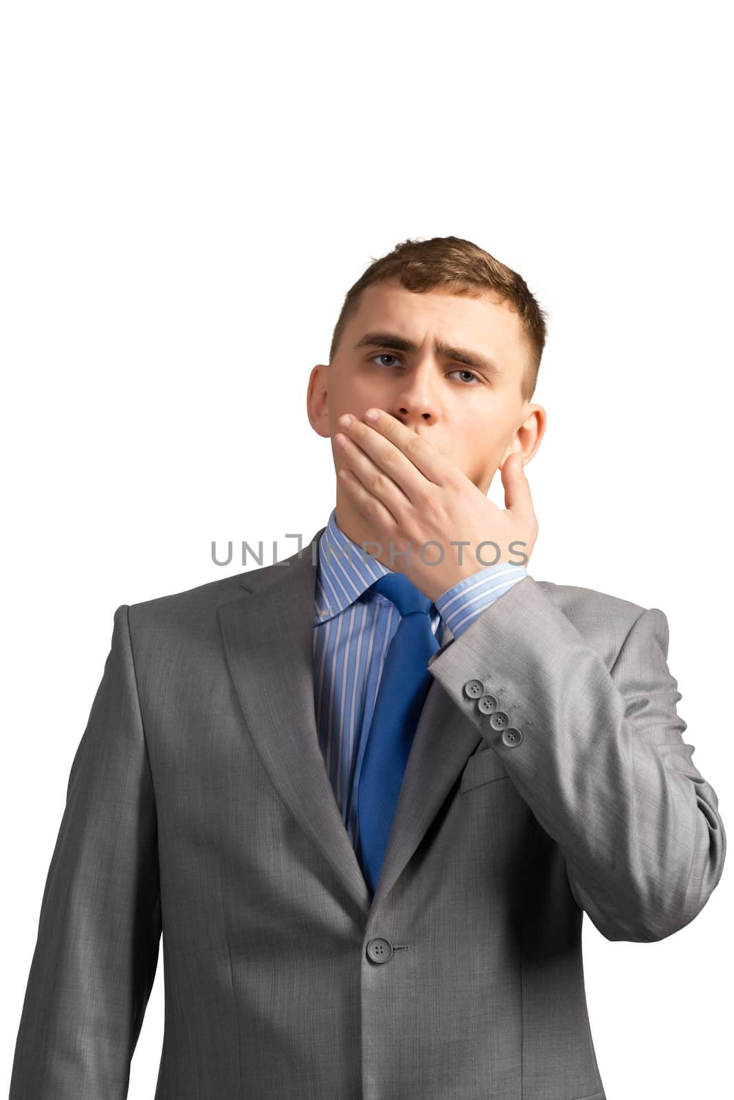 Portrait of a tired young businessman yawning behind her hand, isolated on white background