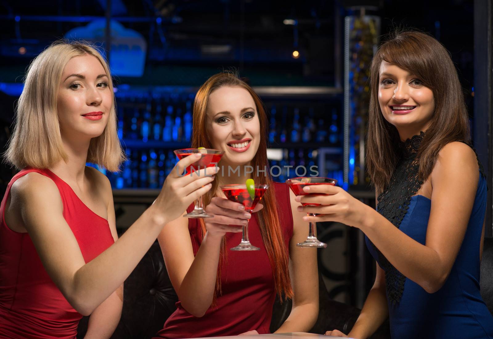 three girls raised their glasses in a nightclub, have fun with friends