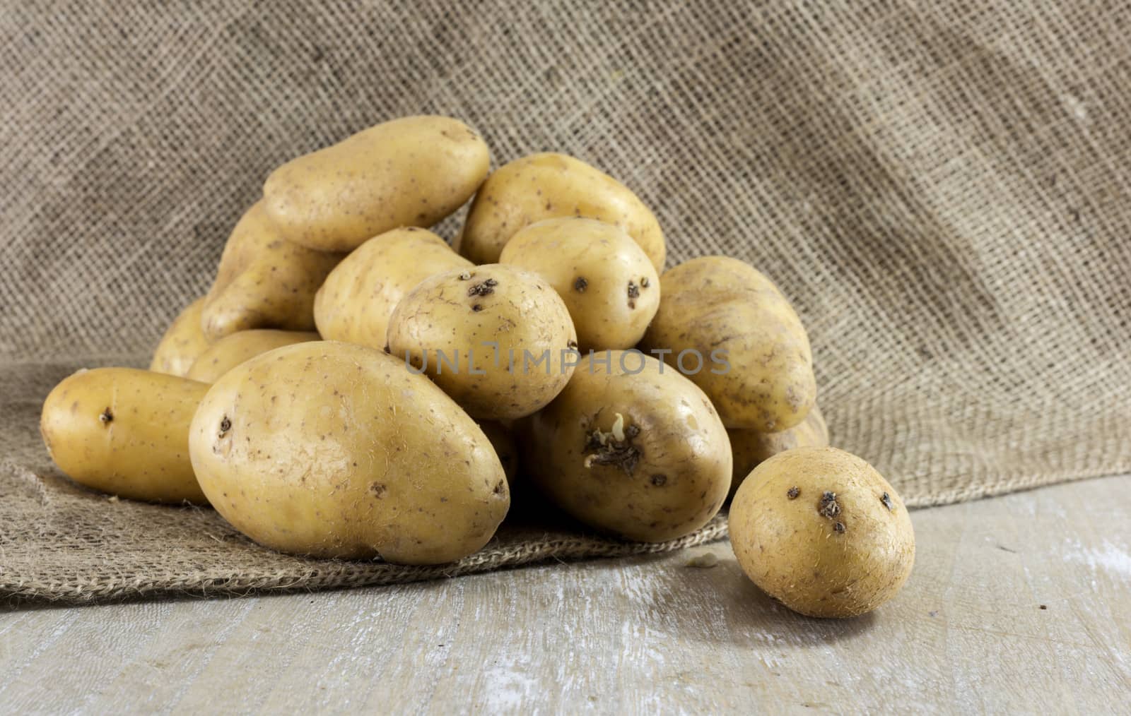 potatoes  and jute background on wooden table