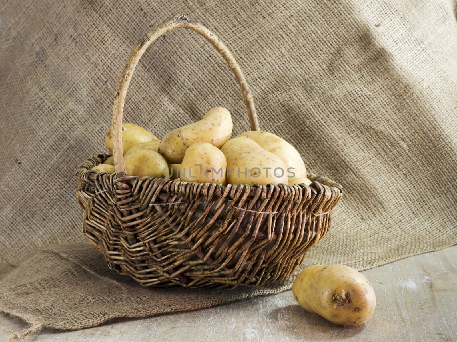 basket with potatoes  and jute background