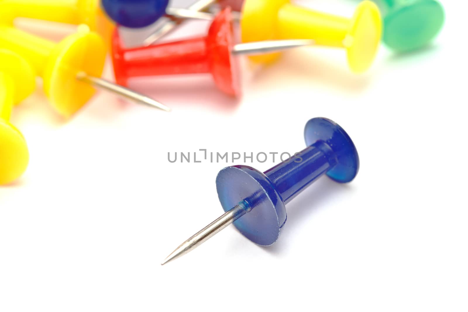 Colorful office push pins closeup on white