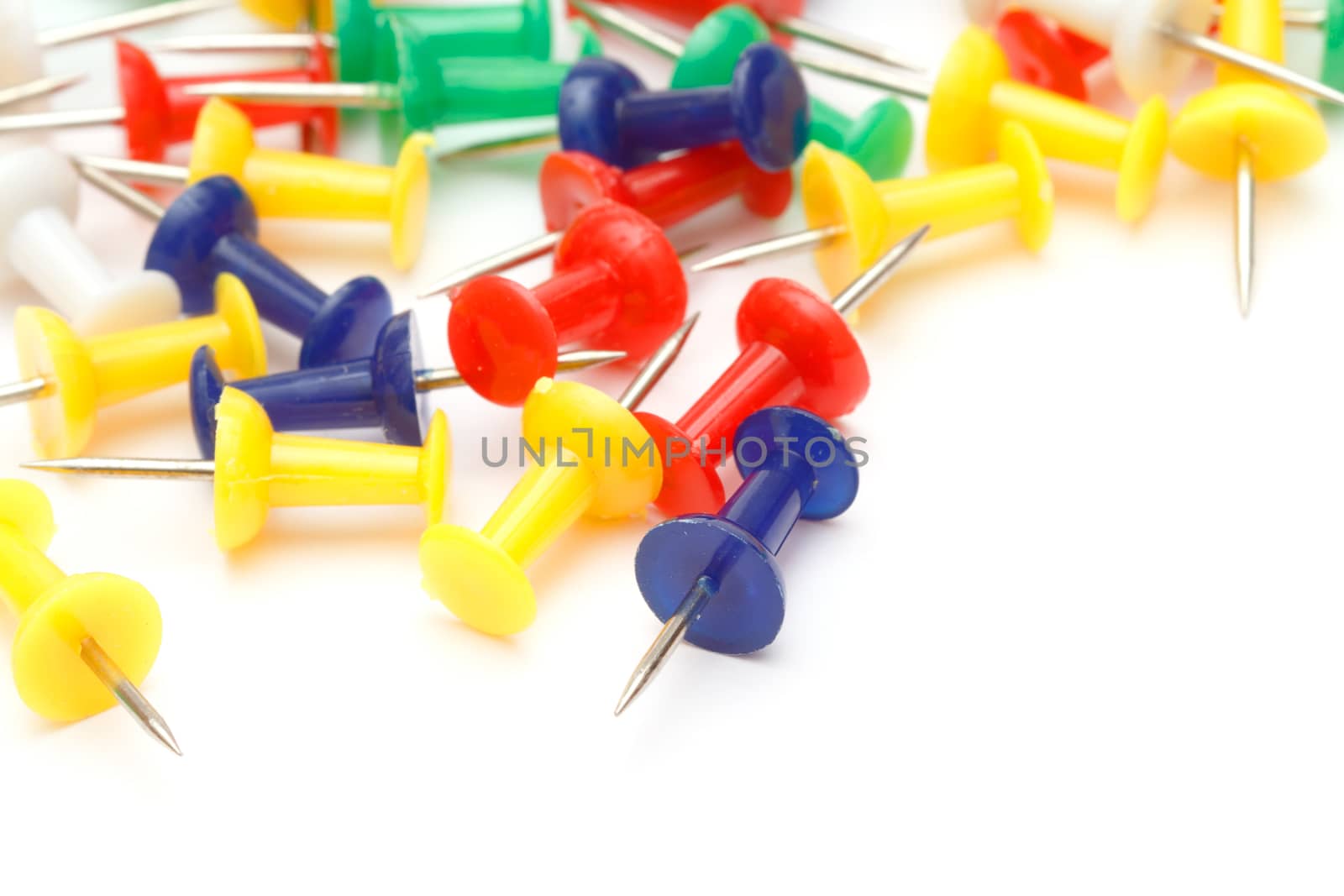 Colorful office push pins closeup on white