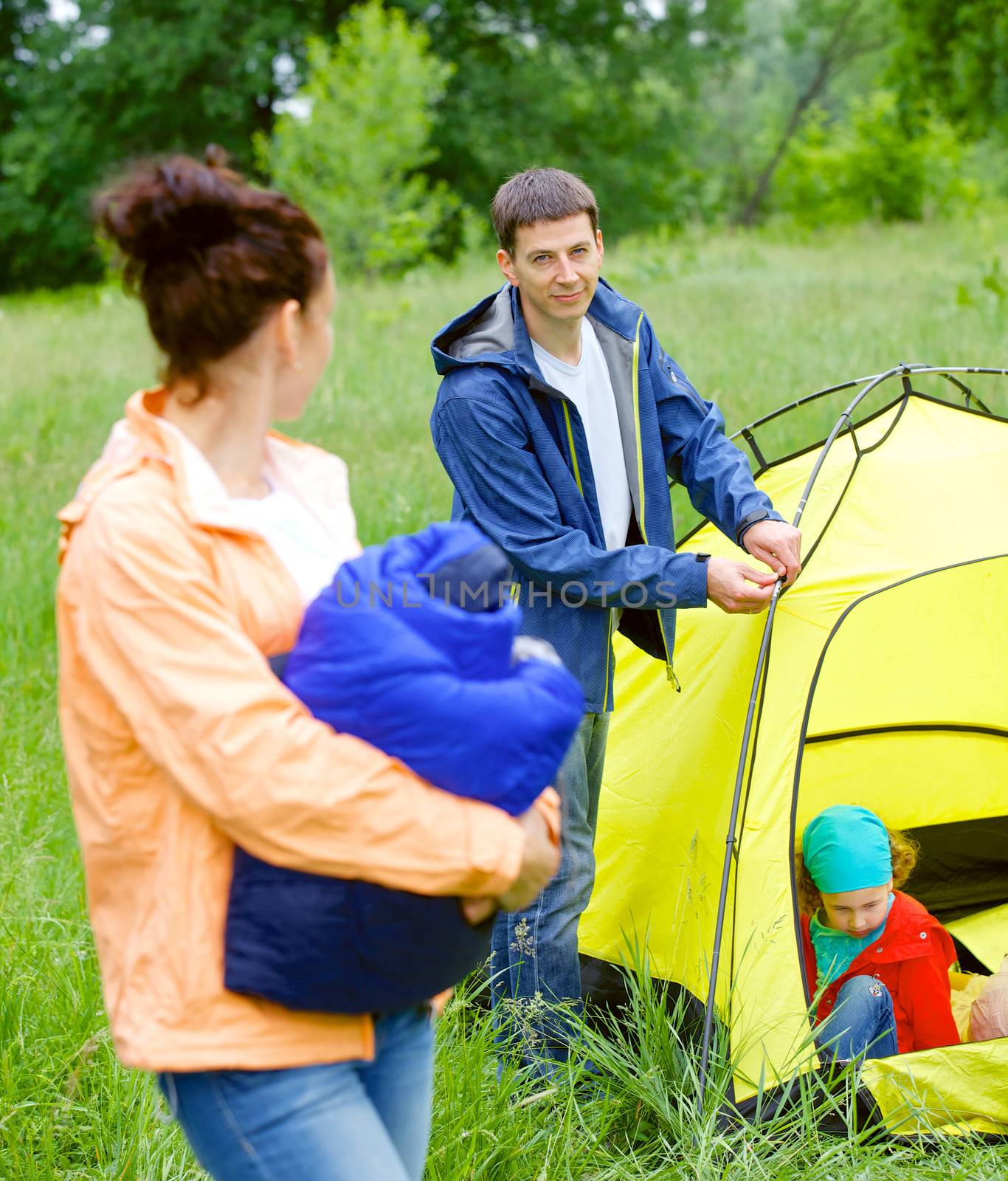 Young man camping near tent in the park