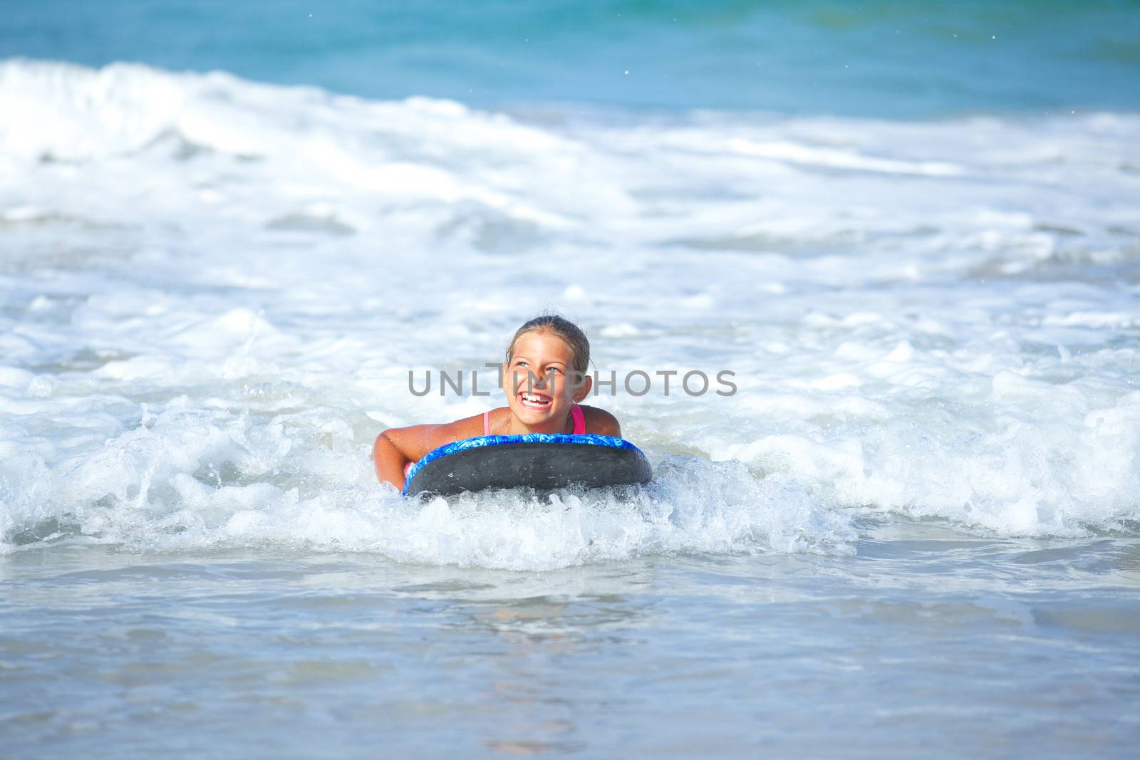 Summer vacation - Happy cute girl having fun with surfboard in the ocean