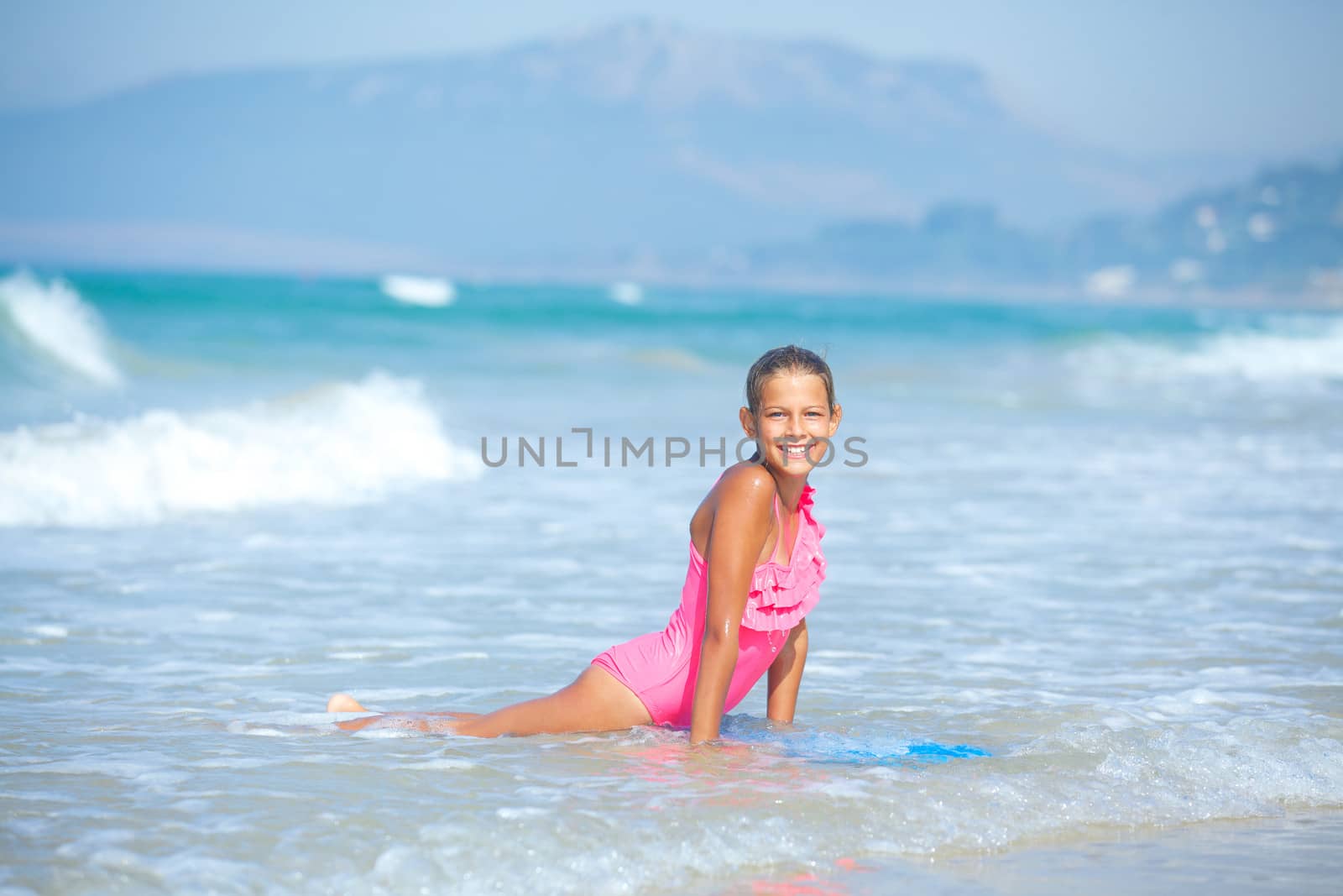 Summer vacation - Happy cute girl having fun with surfboard in the ocean
