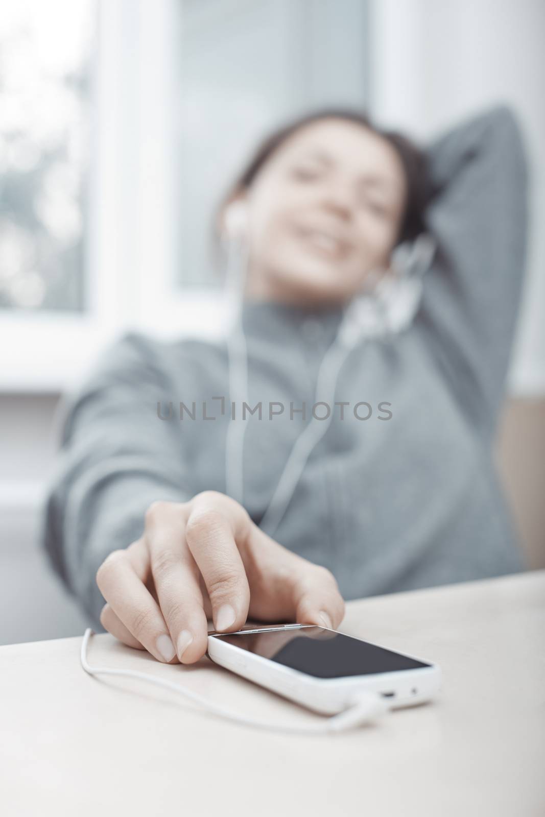 Smiling woman listening music from smartphone