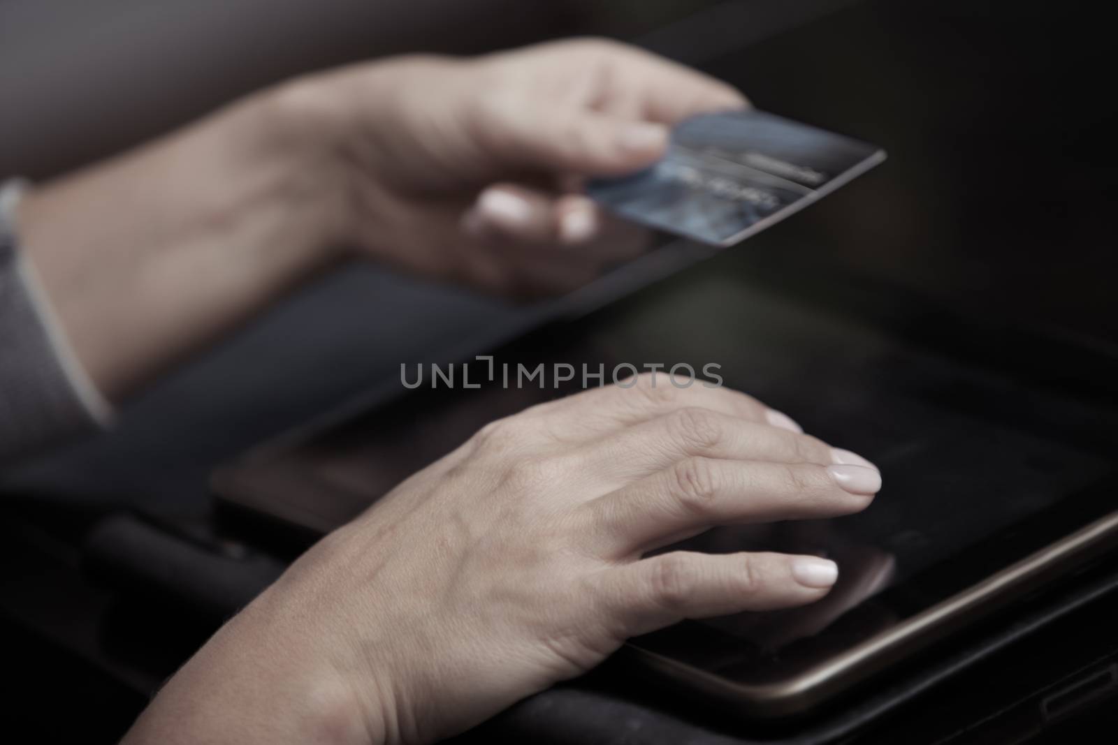 Woman hands holding credit card and tablet computer
