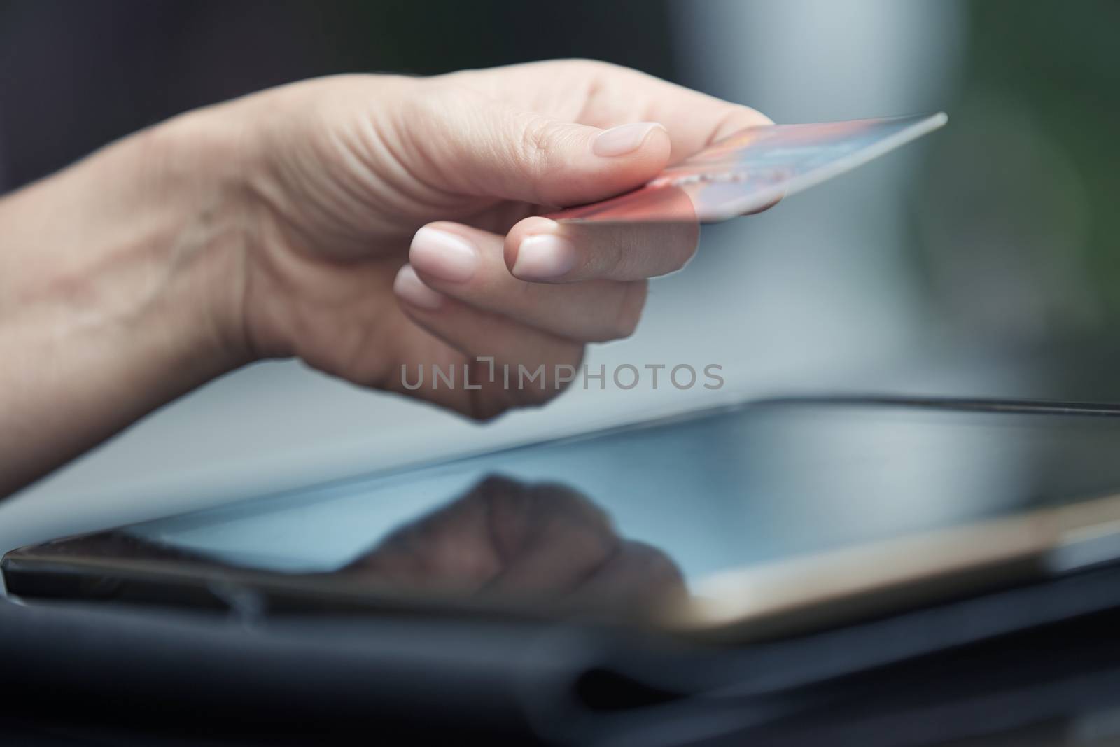 Human hand with digital tablet and credit card