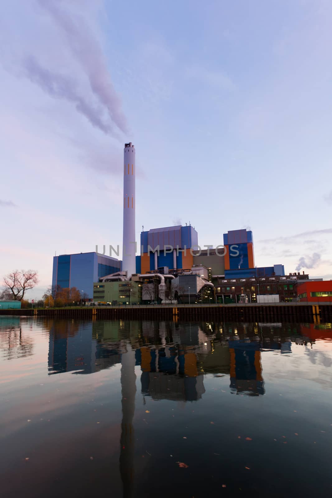 Building complex of modern waste-to-energy facility mirrored on water surface of Rhein-Herne-Kanal in Oberhausen, Germany, Europe