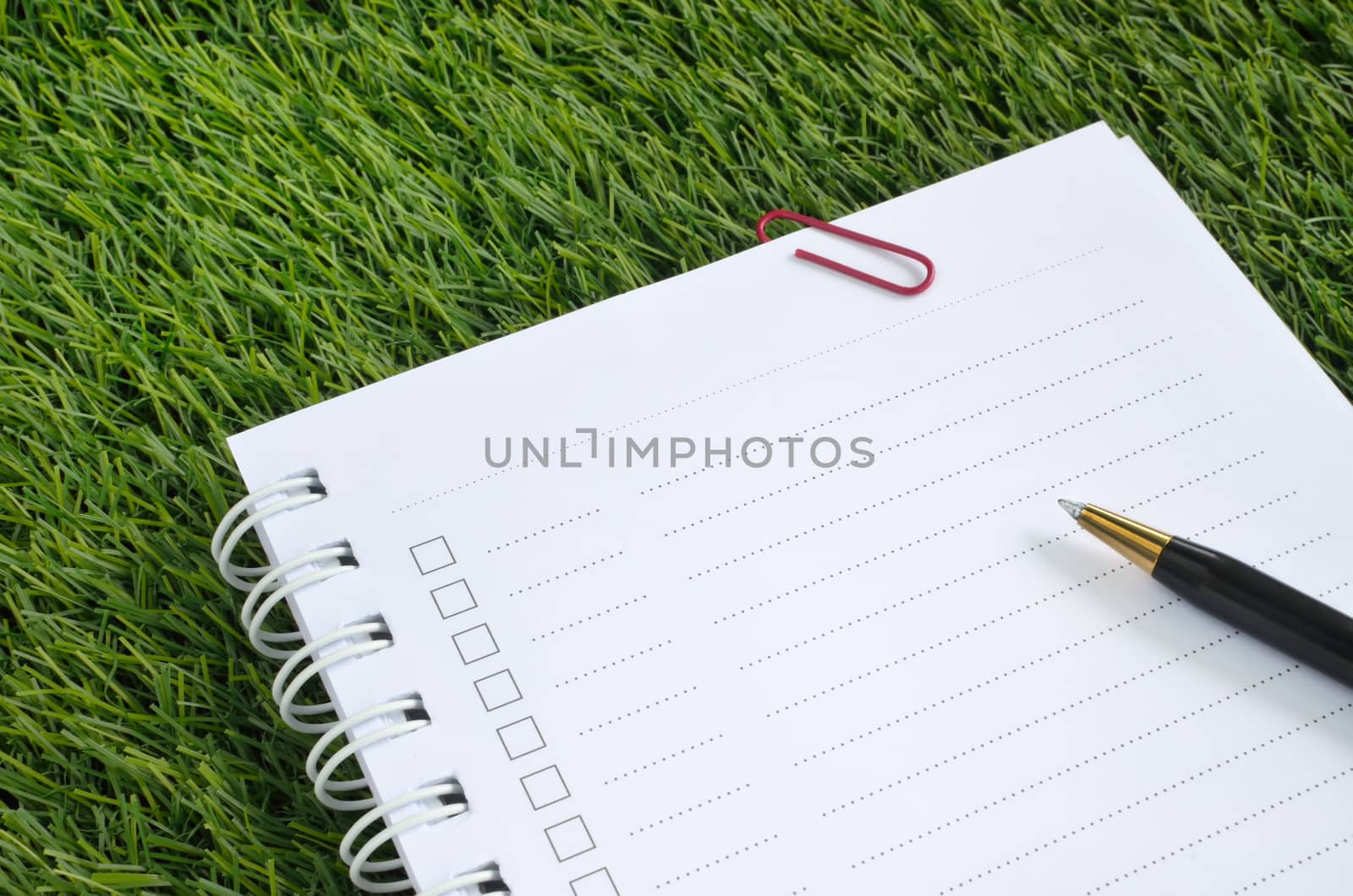 notebook and pen on artificial grass