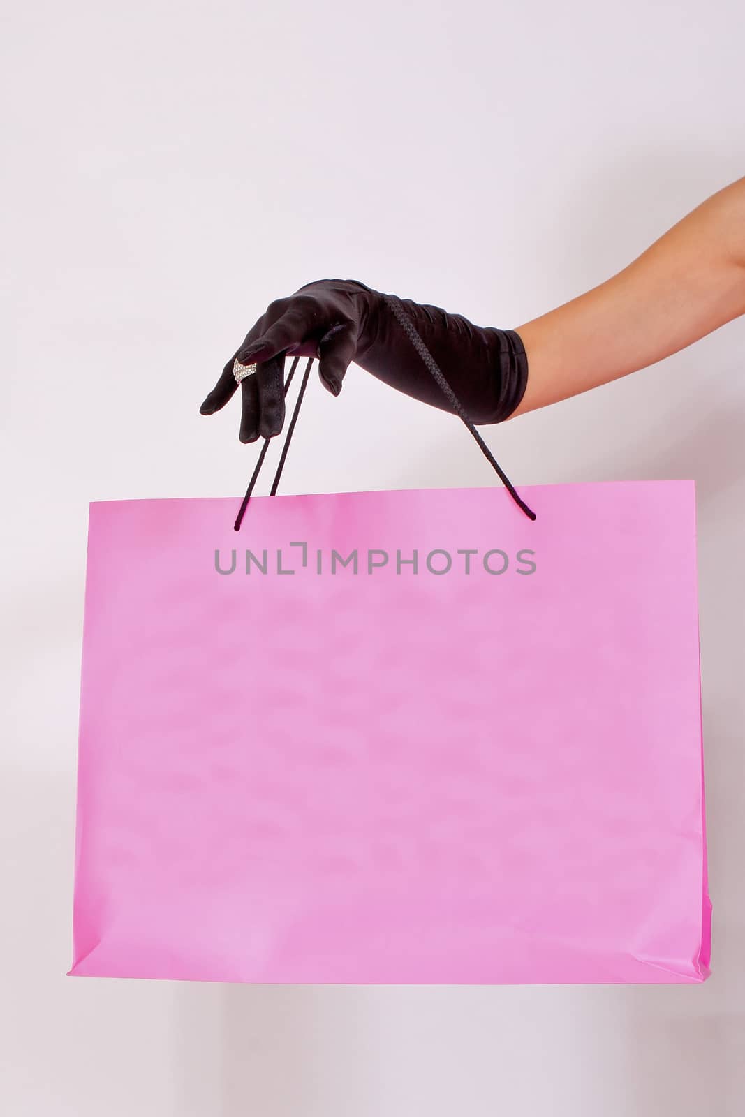 Female hand holding shopping paper bag by dukibu