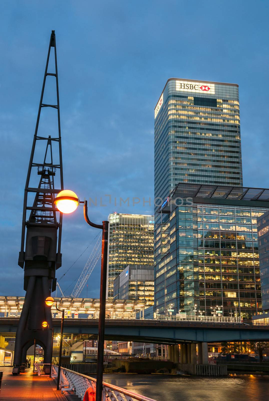 London, United Kingdom - May 9, 2011: HSBC's world Head Quarters building and old port cranes at Canary Wharf. It is part of the redevelopment around Canary Wharf in the London Docklands at night.
