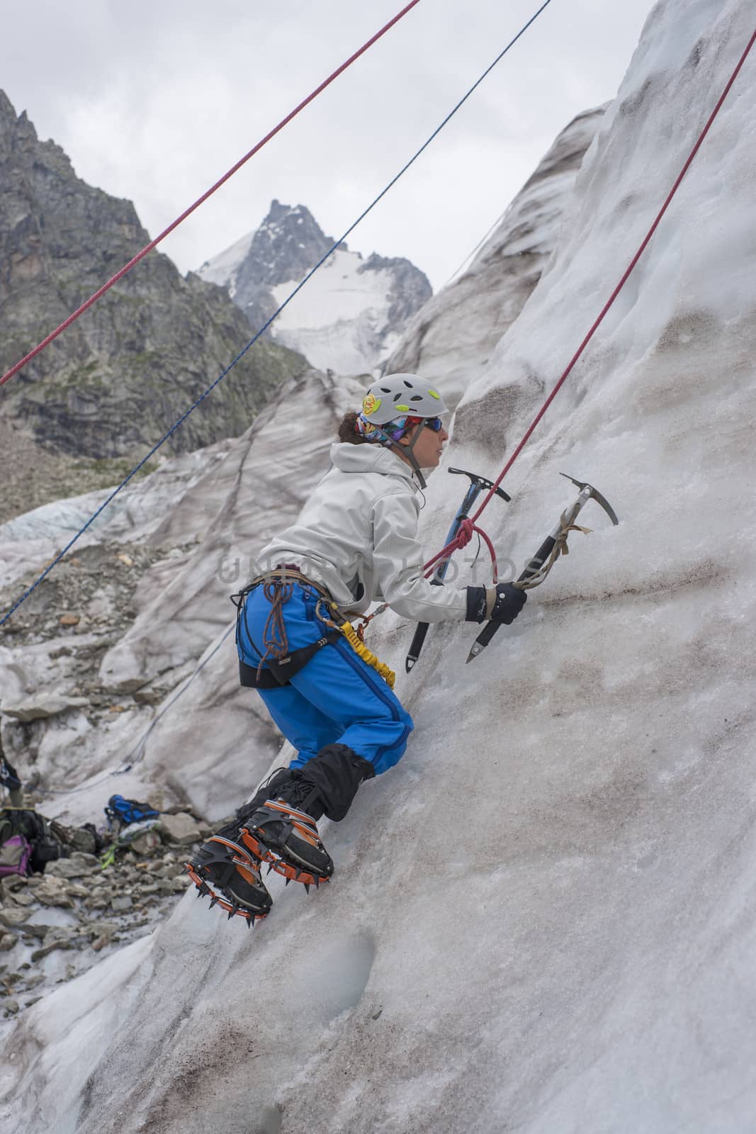 Girl climb up on the ice at glacier