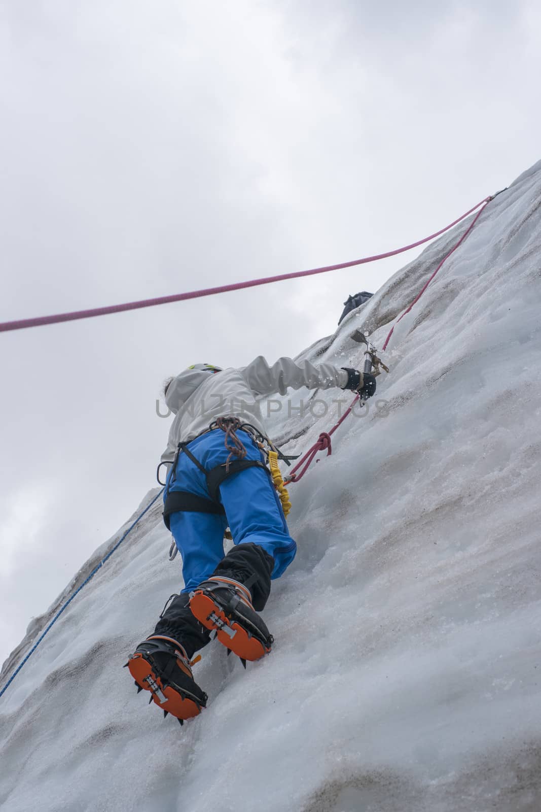 Girl climb up on the ice at glacier