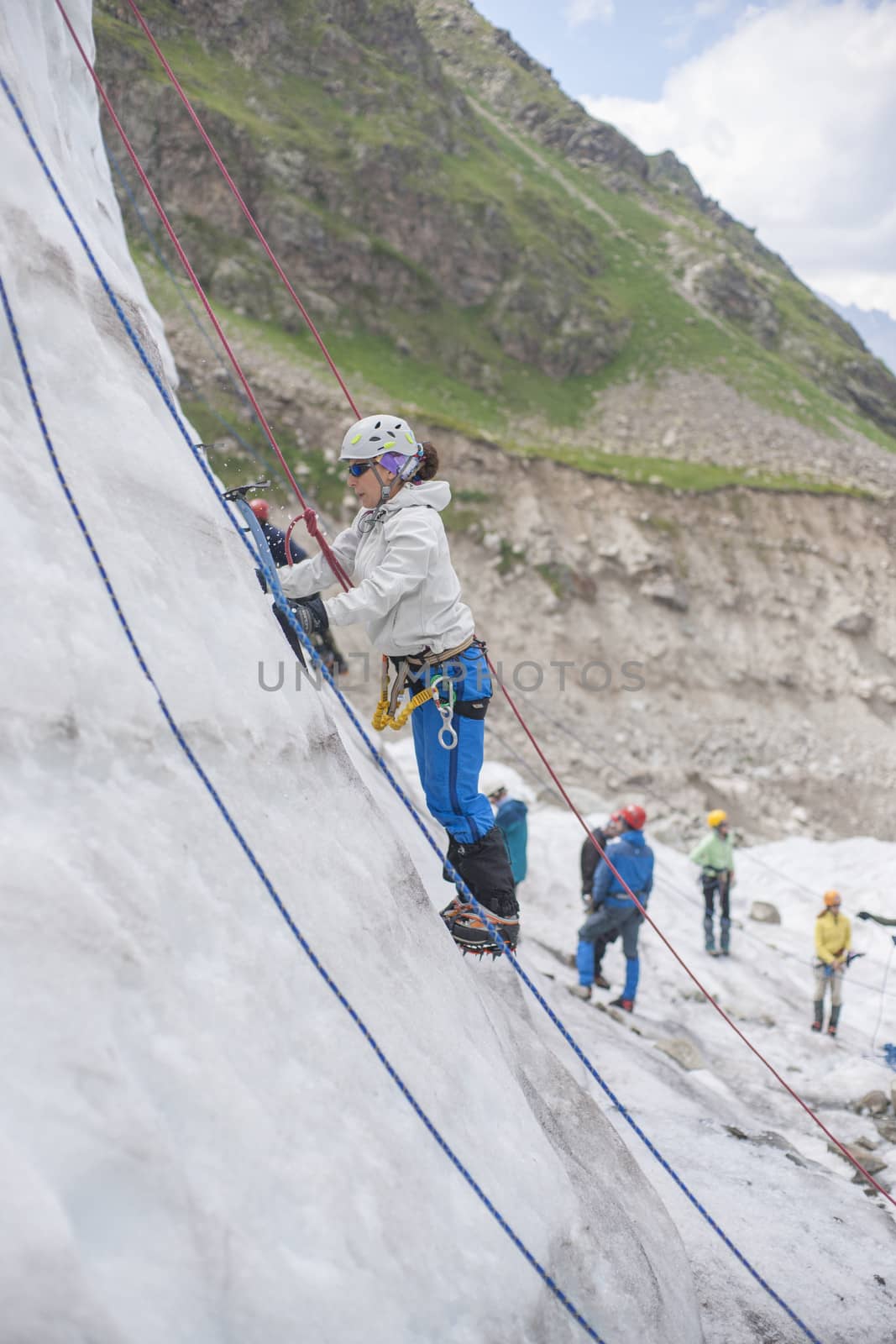 Girl climb up on the ice at glacier