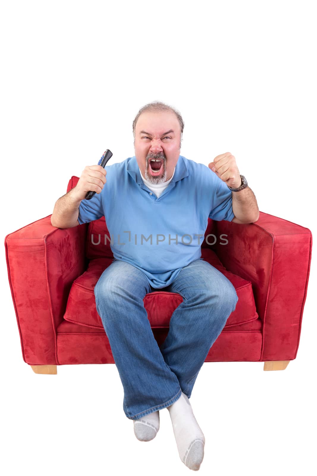 Middle-aged bearded man screaming at the television in anger or as he cheers on his favourite sports team while holding the remote control in his hand , isolated on white