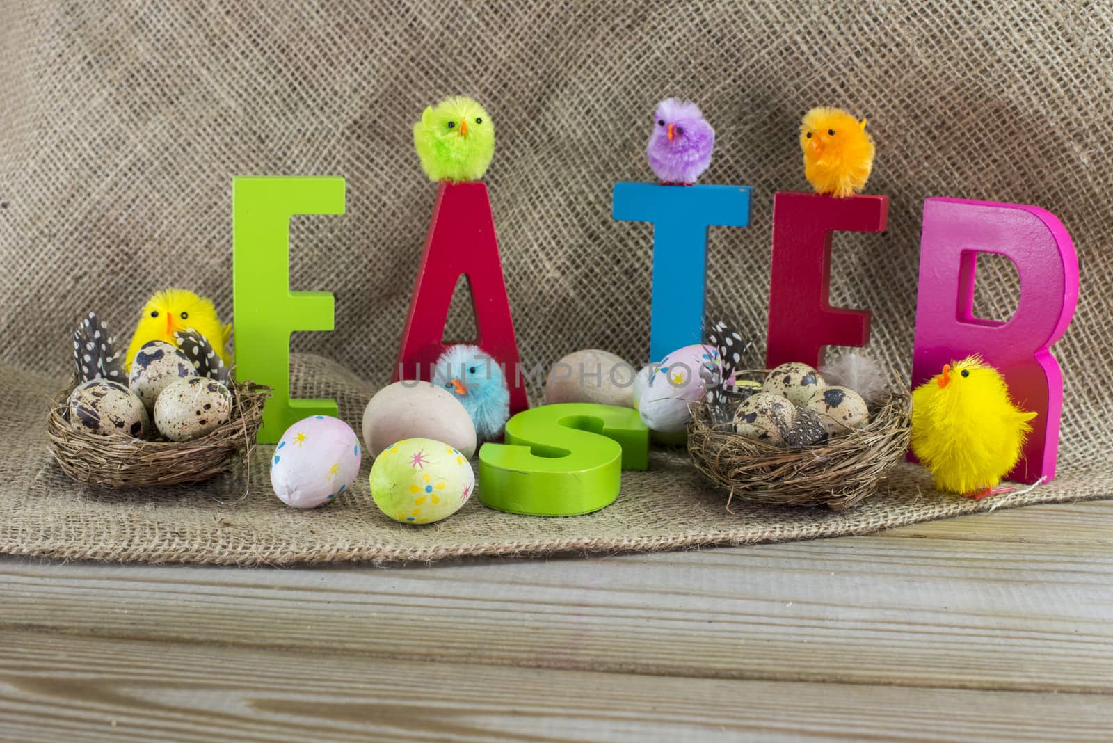 easter with letters on wooden table and jute background