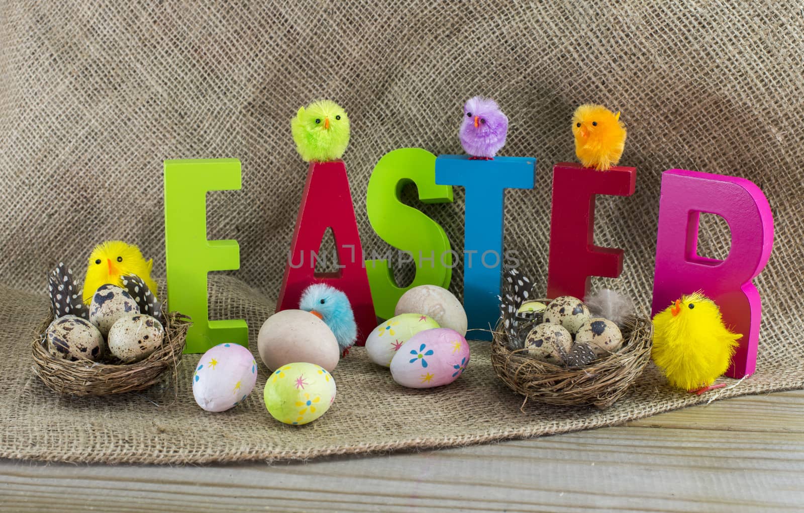 easter with letters on wooden table and jute background