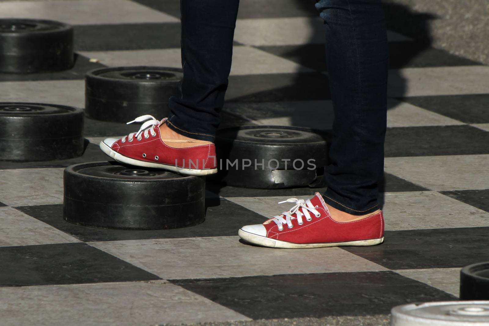Female red shoes playing at a giant outdoor checkers
