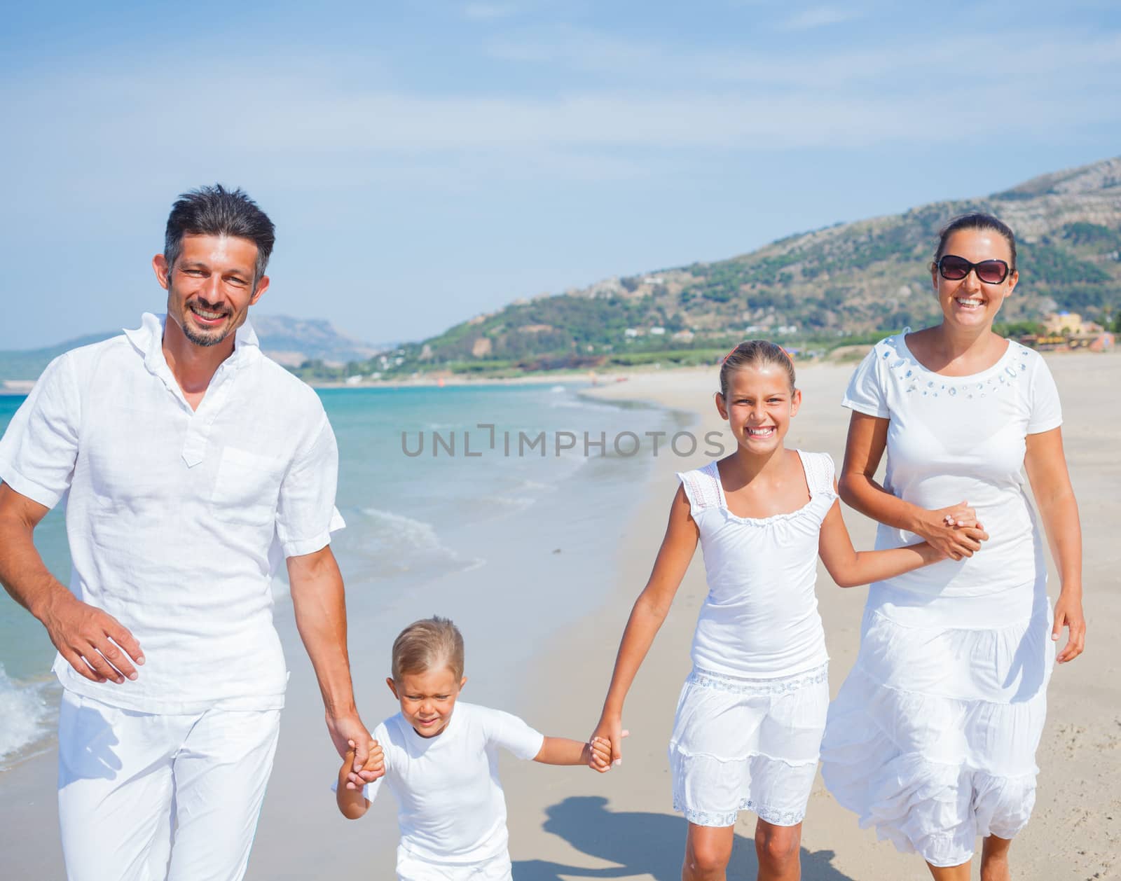 Photo of happy family running on the beach