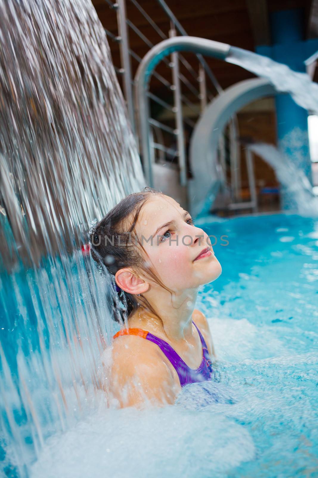 Activities on the pool. Cute girl swimming and playing in water in thermal hot pool