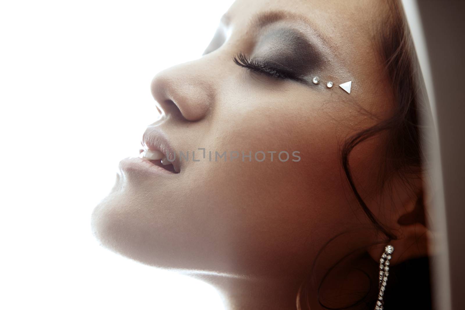 Sensual Asian lady with closed eyes feeling good on a white background
