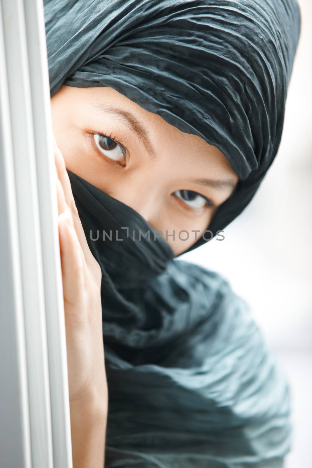 Oriental lady in black hijab hiding