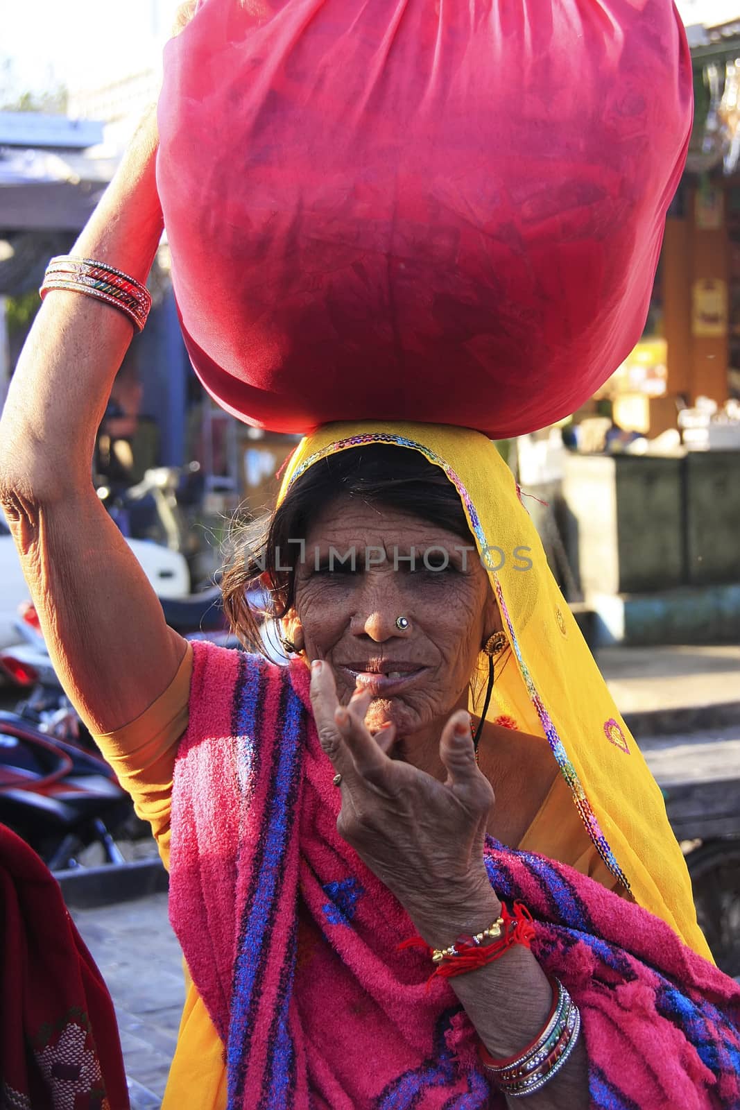 Indian woman carrying bundle on her head, Bundi, India by donya_nedomam