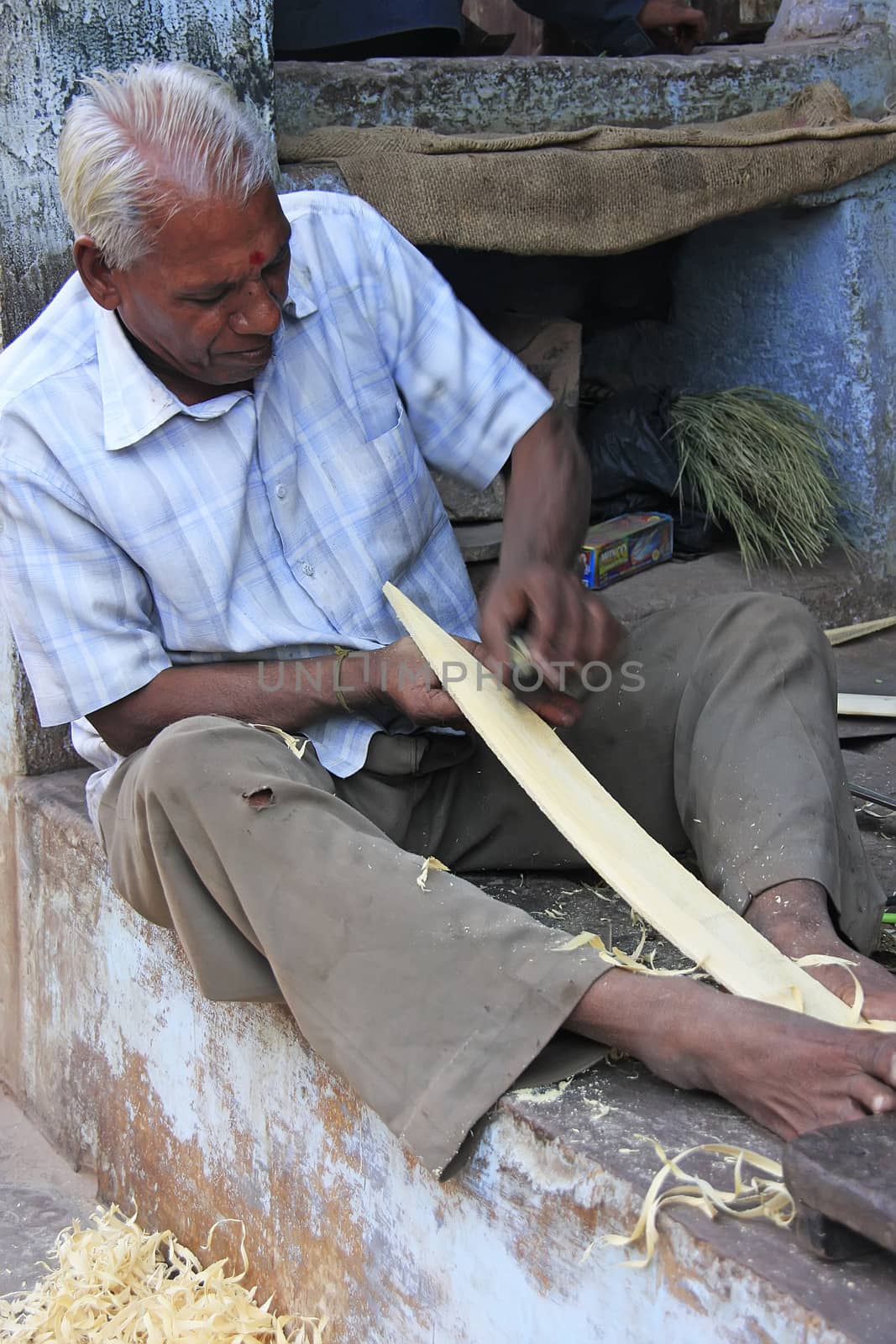 Indian man working with wood in the street, Bundi, India by donya_nedomam