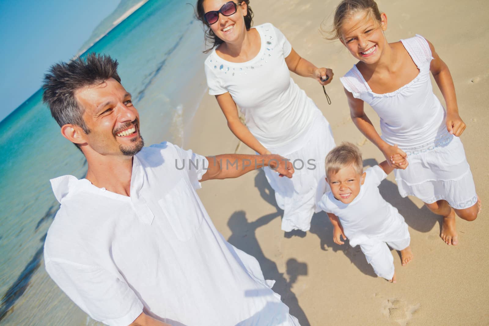 Photo of happy family running on the beach